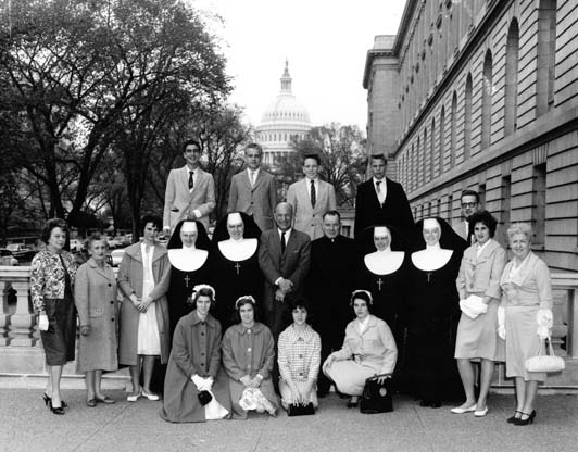 1961 graduates and staff of St. Joseph's Village pose with Congressman with the U.S. Capital in the distance.